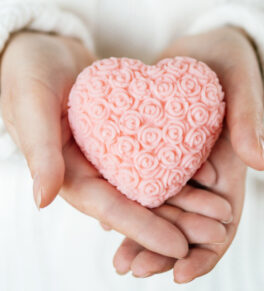 a pink heart-shaped glycerin soap held in the hands