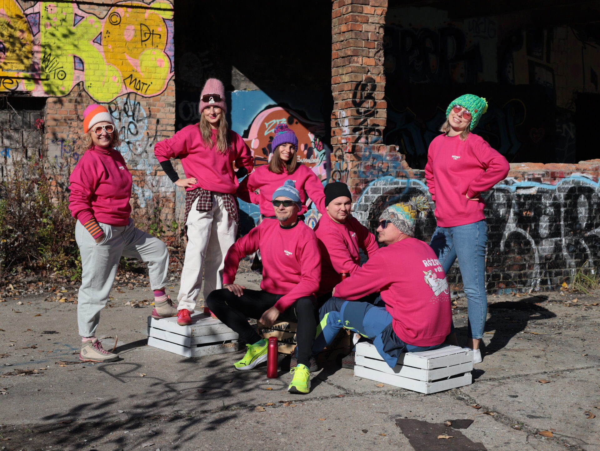 grupa ludzi na tle grafitti w różowych bluzach Shots! Różowy w Ch!